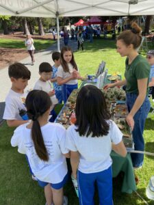 A group of children gather around a watershed model.