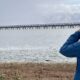 A participant peers through binoculars to view birds in the water.