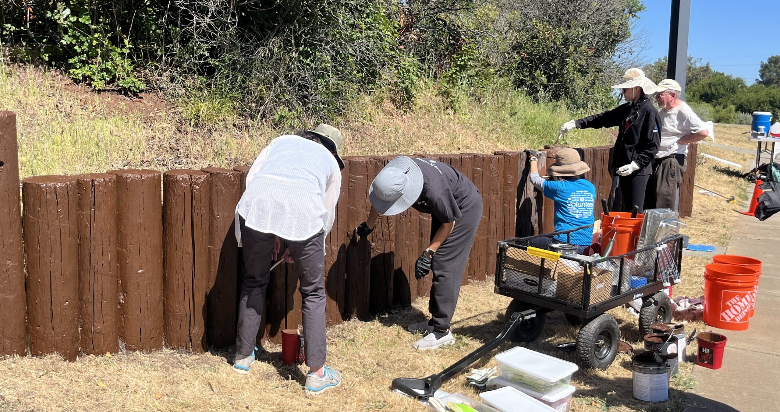 A group of volunteers paints bollards at the Don Edwards SF Bay National Wildlife Refuge.
