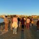 A group of people gather at Bair Island during sunset