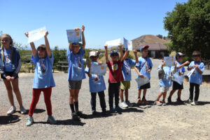 Campers holding up certificates.