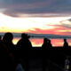 Silhouettes of visitors observing the marsh at sunset.